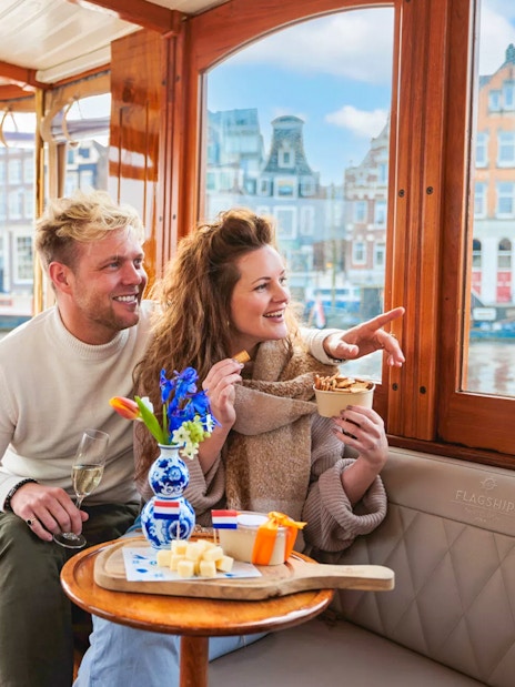 Couple enjoying a luxury romantic cruise in Amsterdam with city views.