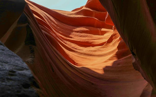 Upper Antelope Canyon's smooth, wave-like sandstone formations illuminated by sunlight.