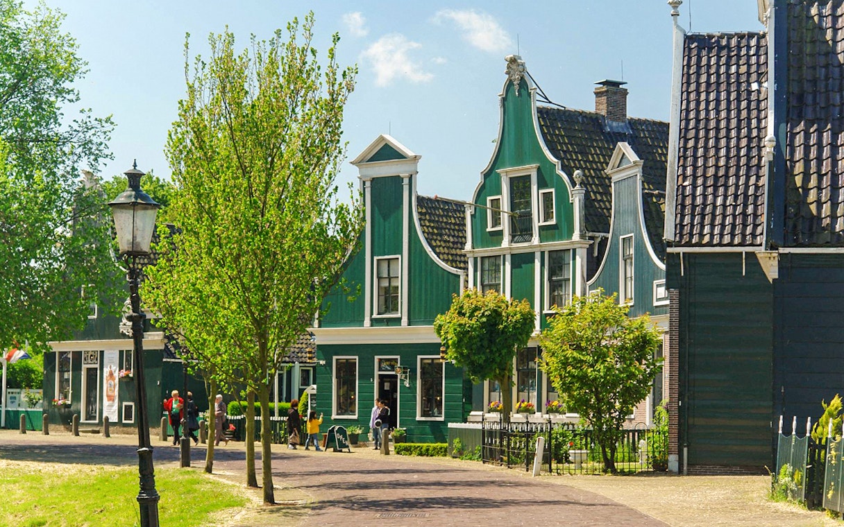 Zaanse Schans traditional green houses and trees on a sunny day.