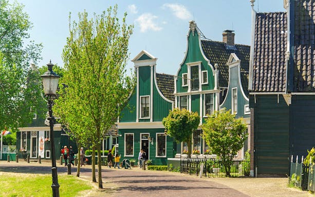 Zaanse Schans traditional green houses and trees on a sunny day.