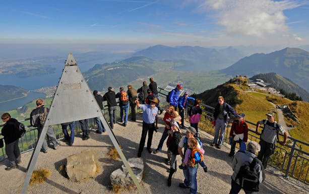 Tourists enjoying panoramic views from Mount Stanserhorn summit near Zürich.