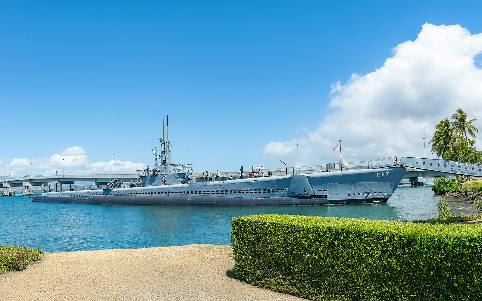 USS Bowfin Submarine SS-287 docked at Pearl Harbor with visitors on deck.