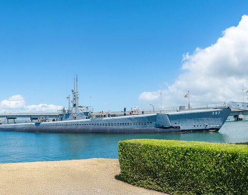 USS Bowfin Submarine SS-287 docked at Pearl Harbor with visitors on deck.