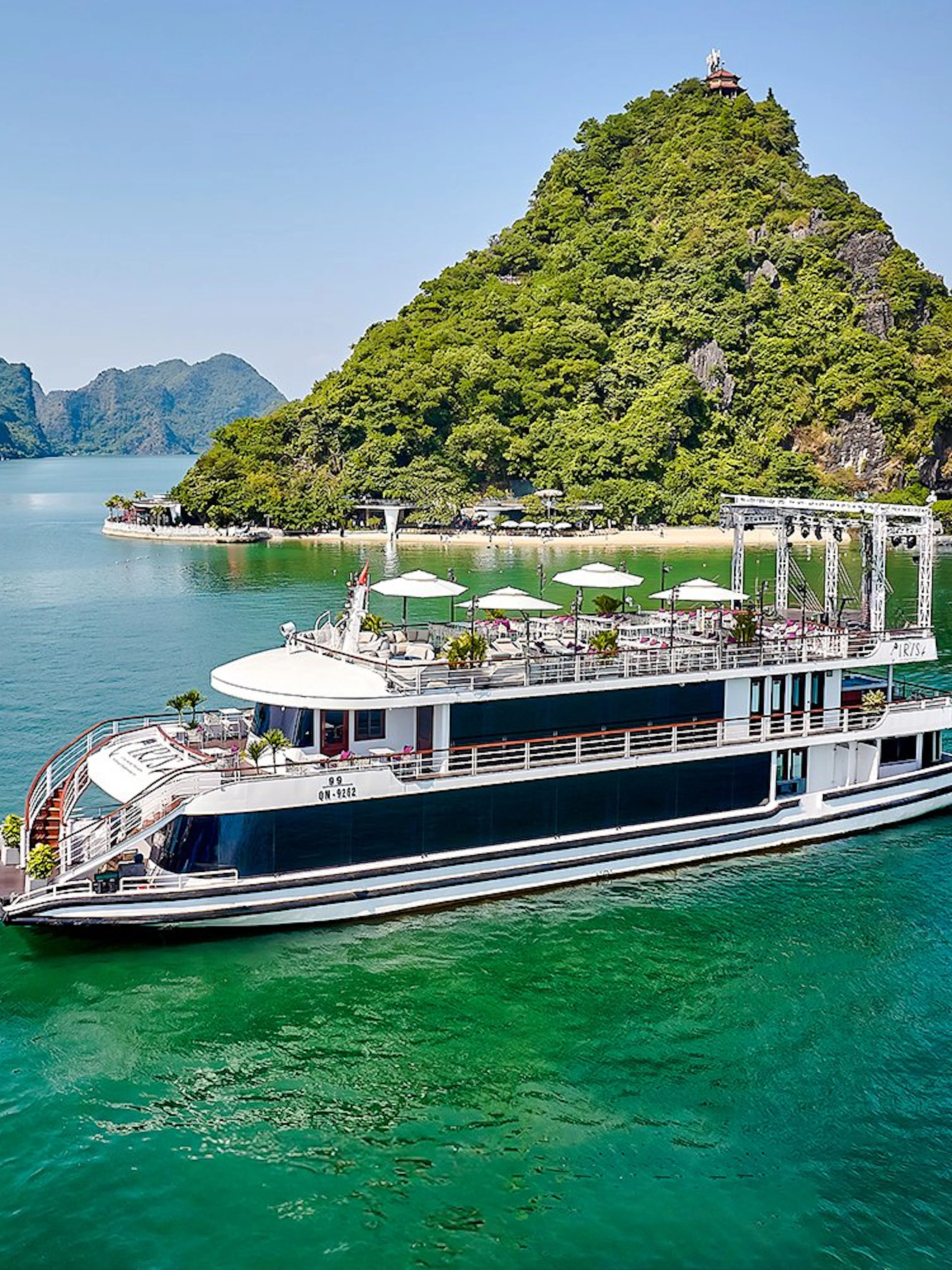 Luxury cruise ship sailing in Ha Long Bay with limestone islands in the background.