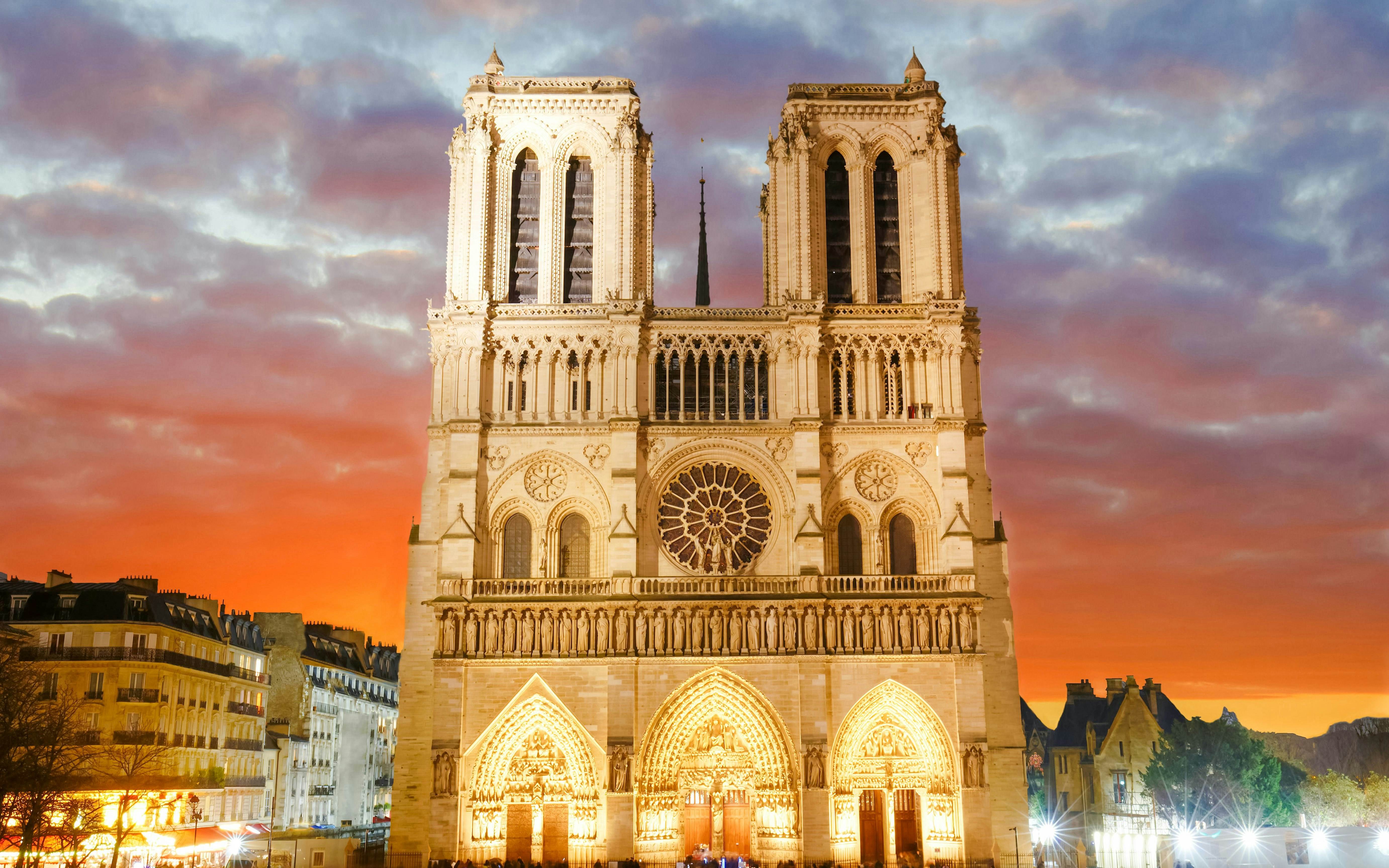 Notre Dame Cathedral in Paris with a vibrant sunset sky.