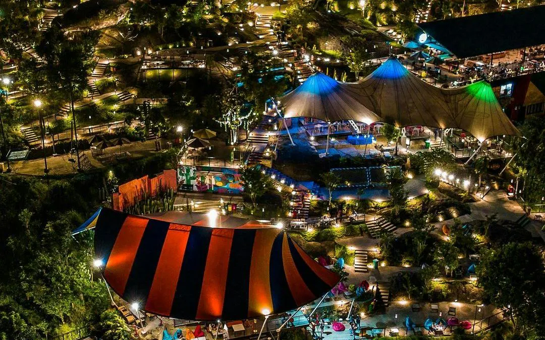 Night view of illuminated outdoor entertainment area with colorful tents in Dubai.