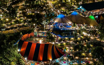 Night view of illuminated outdoor entertainment area with colorful tents in Dubai.