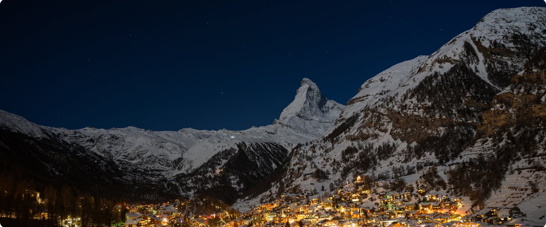 Zermatt village at night with the Matterhorn mountain in the background.