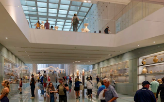 Visitors exploring exhibits inside Acropolis Museum, Athens.