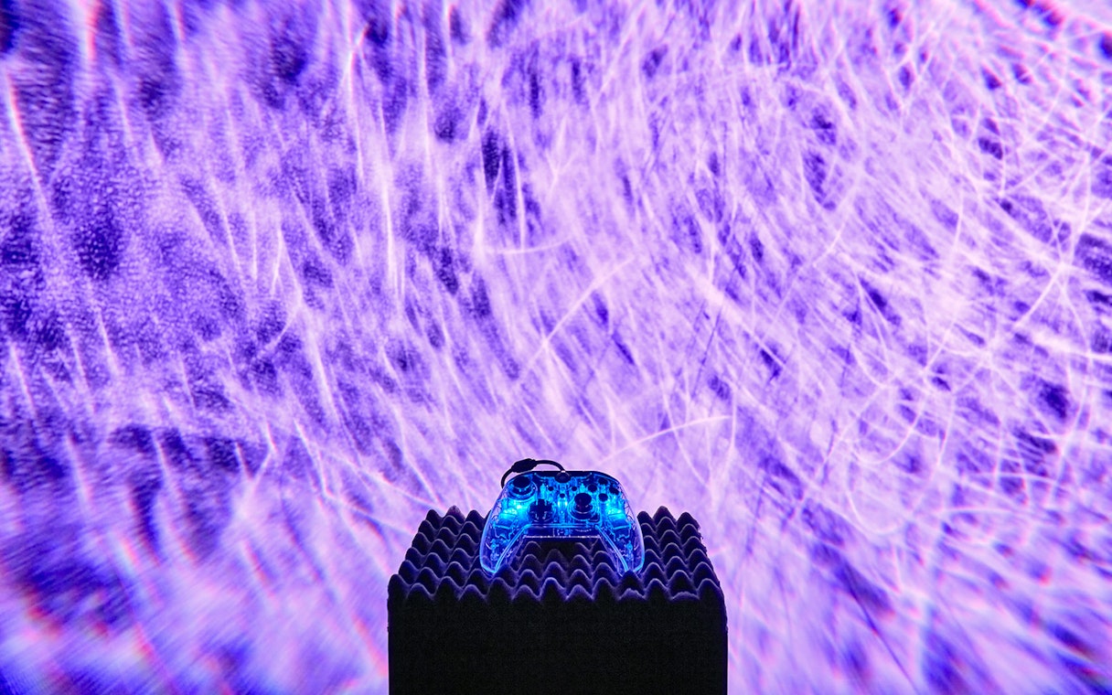 Interactive light display at Light Art Museum with glowing controller.