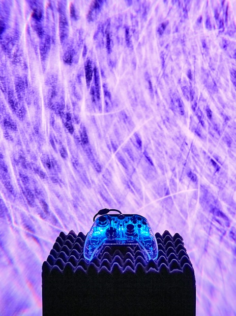 Interactive light display at Light Art Museum with glowing controller.