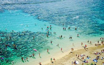 Visitors enjoying the clear waters and sandy beach at Hanauma Bay, Hawaii.