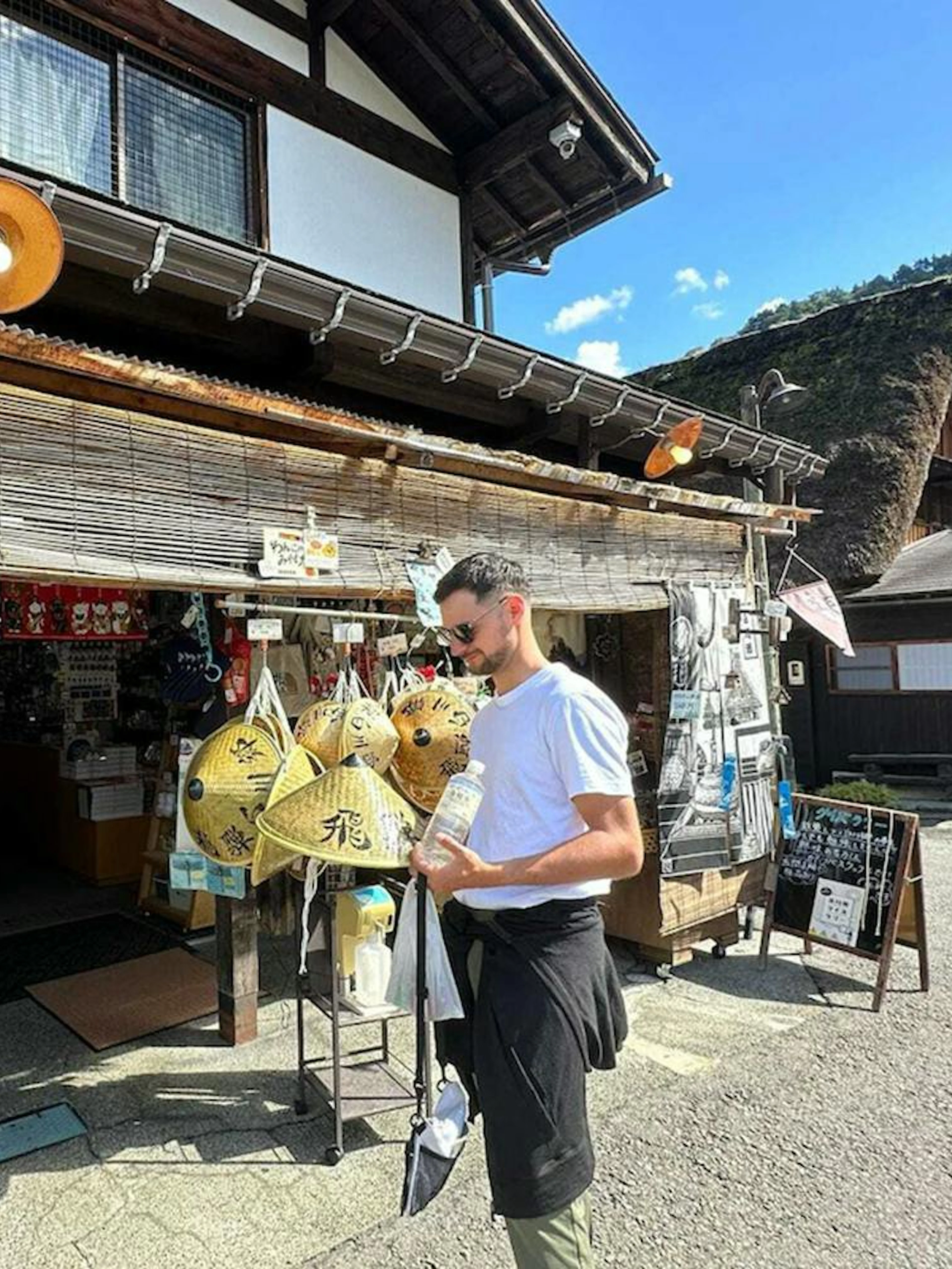 Traditional shop in Shirakawa-go with visitor browsing souvenirs, Kanazawa day tour.