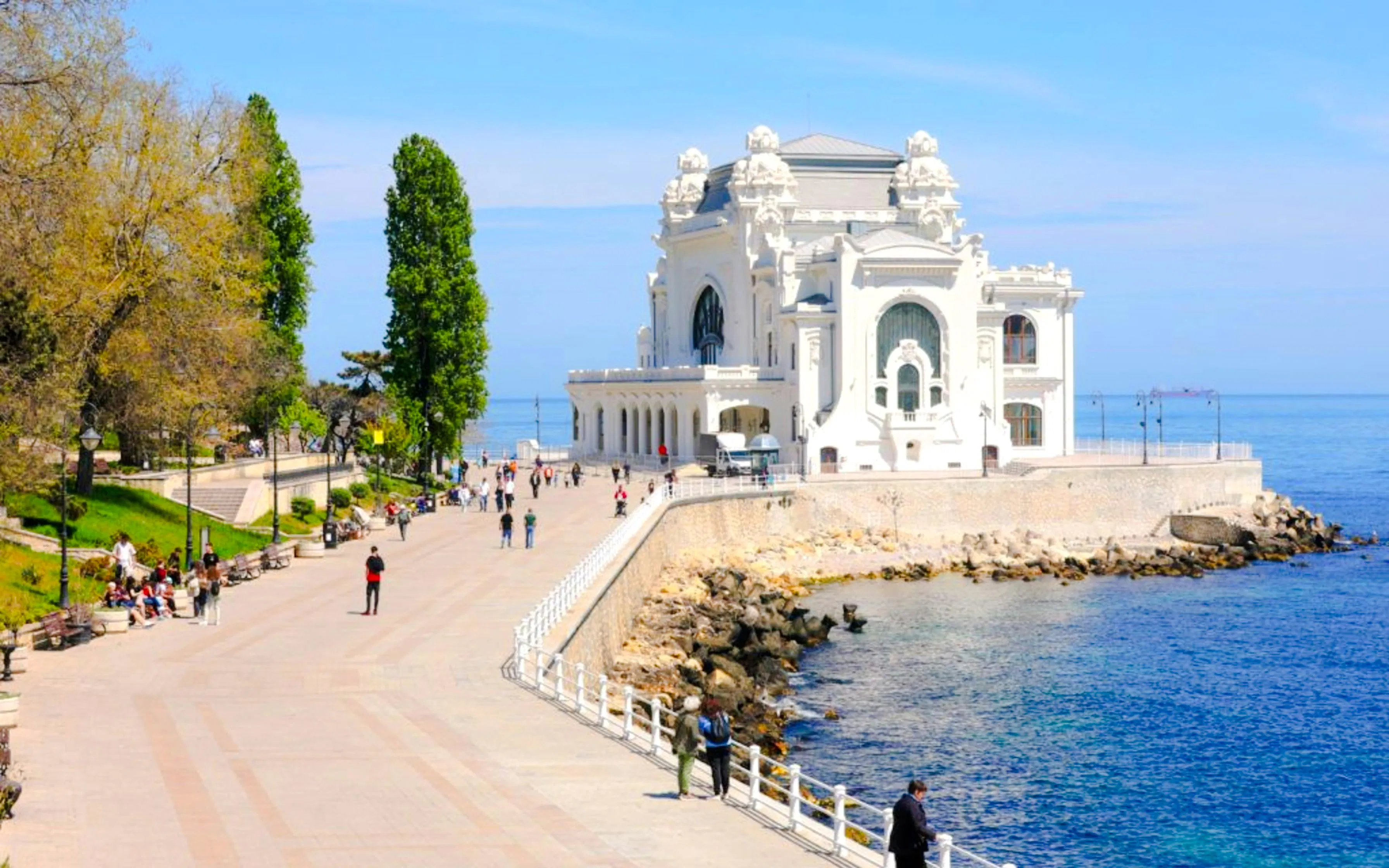 Constanța Casino on the Black Sea coast with promenade and visitors in Romania.