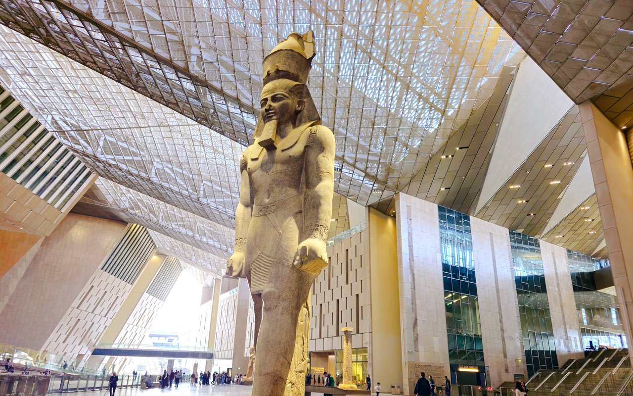Statue of Pharaoh in the Grand Egyptian Museum's modern atrium, Cairo.