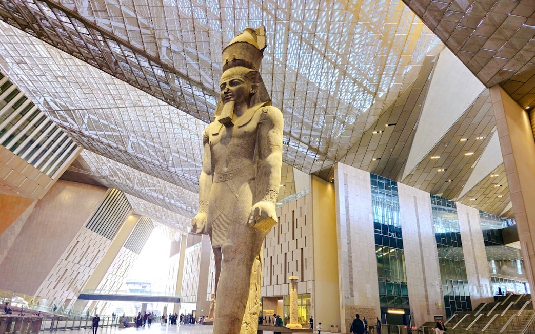Statue of Pharaoh in the Grand Egyptian Museum's modern atrium, Cairo.