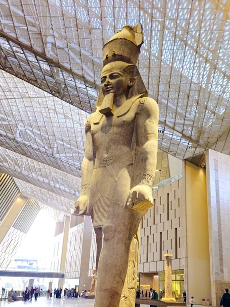 Statue of Pharaoh in the Grand Egyptian Museum's modern atrium, Cairo.