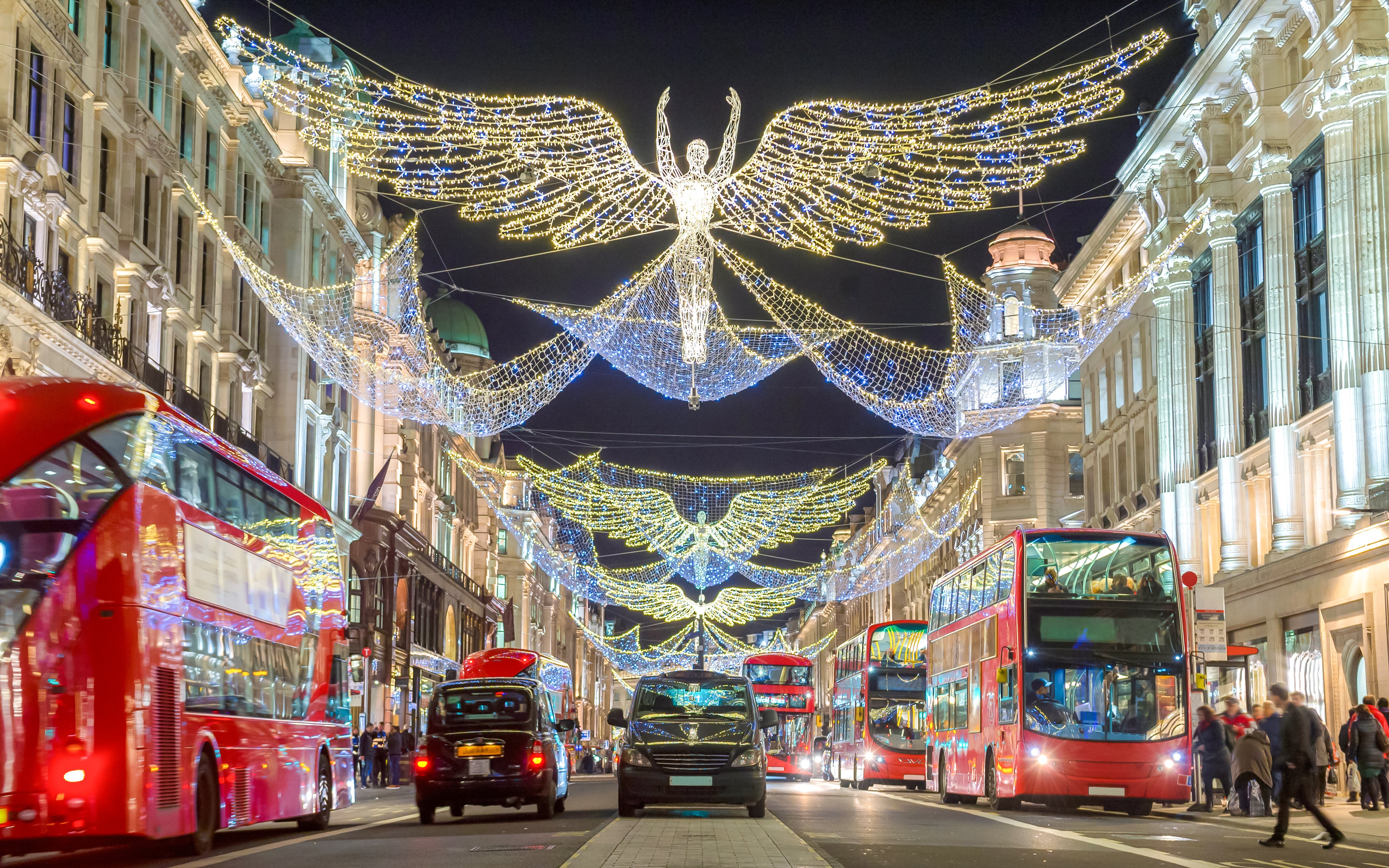 London street with Christmas lights and red double-decker buses.