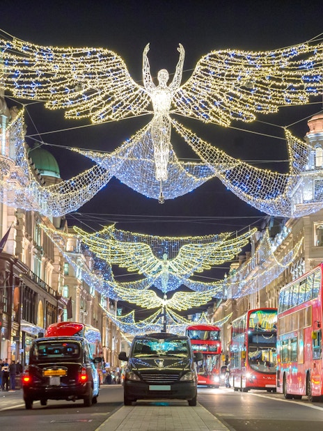 London street with Christmas lights and red double-decker buses.