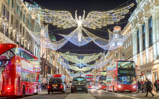 London street with Christmas lights and red double-decker buses.