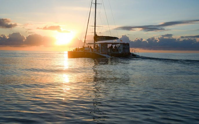 Catamaran sailing at sunrise in Mallorca for dolphin watching.