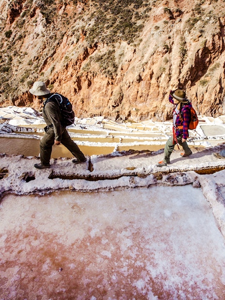 Visitors walking along the Maras Salt Mines terraces in the Sacred Valley, Peru.
