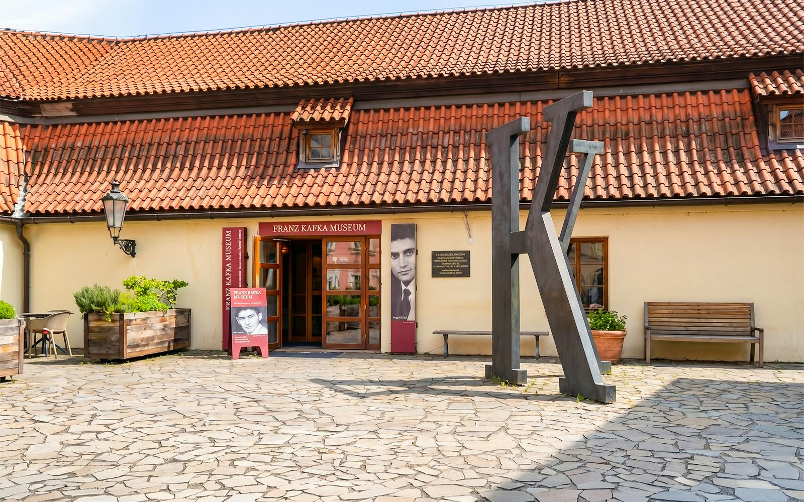 Franz Kafka Museum entrance with large K sculpture, Prague.