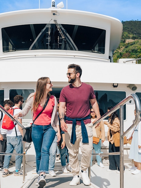 Couple on a boat during Cinque Terre day trip from Florence, with coastal scenery in the background.