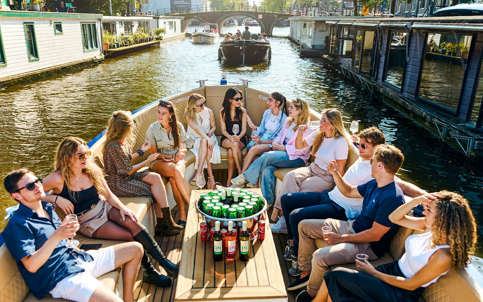 Group enjoying drinks on a canal cruise in Amsterdam's Red Light District.