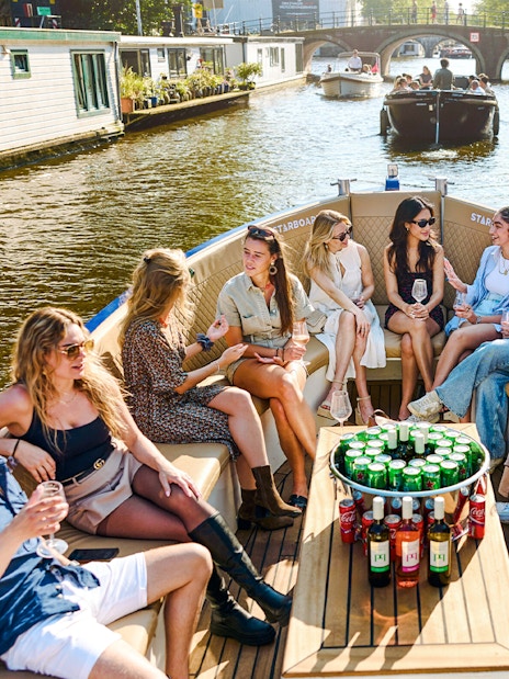 Group enjoying drinks on a canal cruise in Amsterdam's Red Light District.