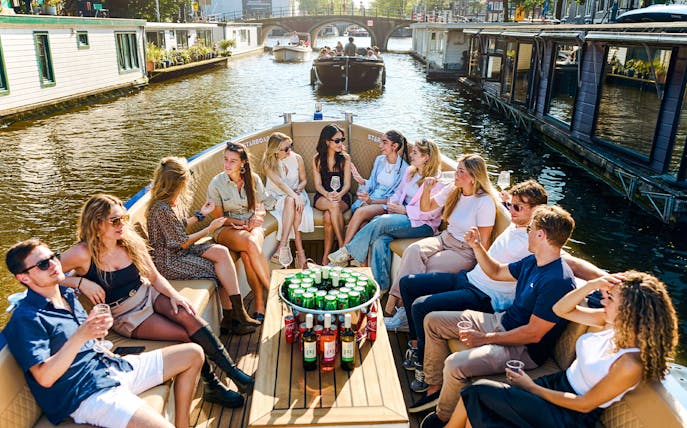 Group enjoying drinks on a canal cruise in Amsterdam's Red Light District.