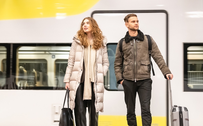 Travelers with luggage at Arlanda Express platform, Stockholm.