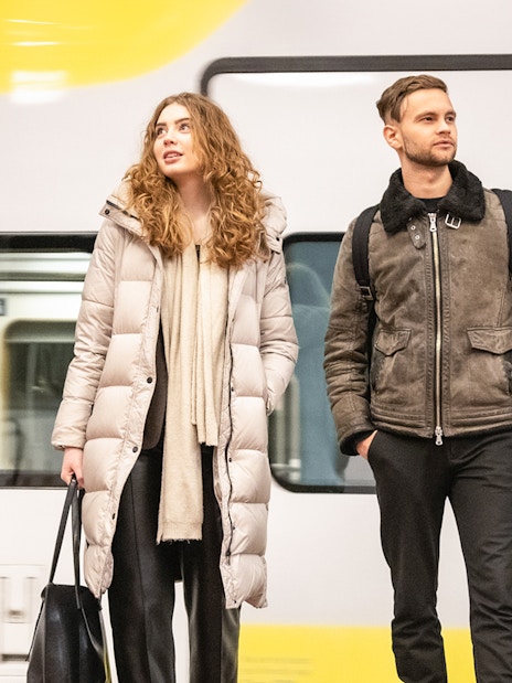 Travelers with luggage at Arlanda Express platform, Stockholm.