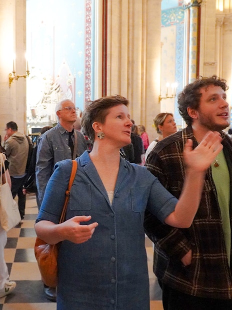 Guide explaining Notre Dame's interior to tourists.