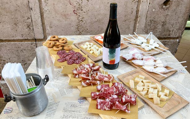 Wine and food tasting setup with cured meats, cheese, and wine in Trastevere, Rome.