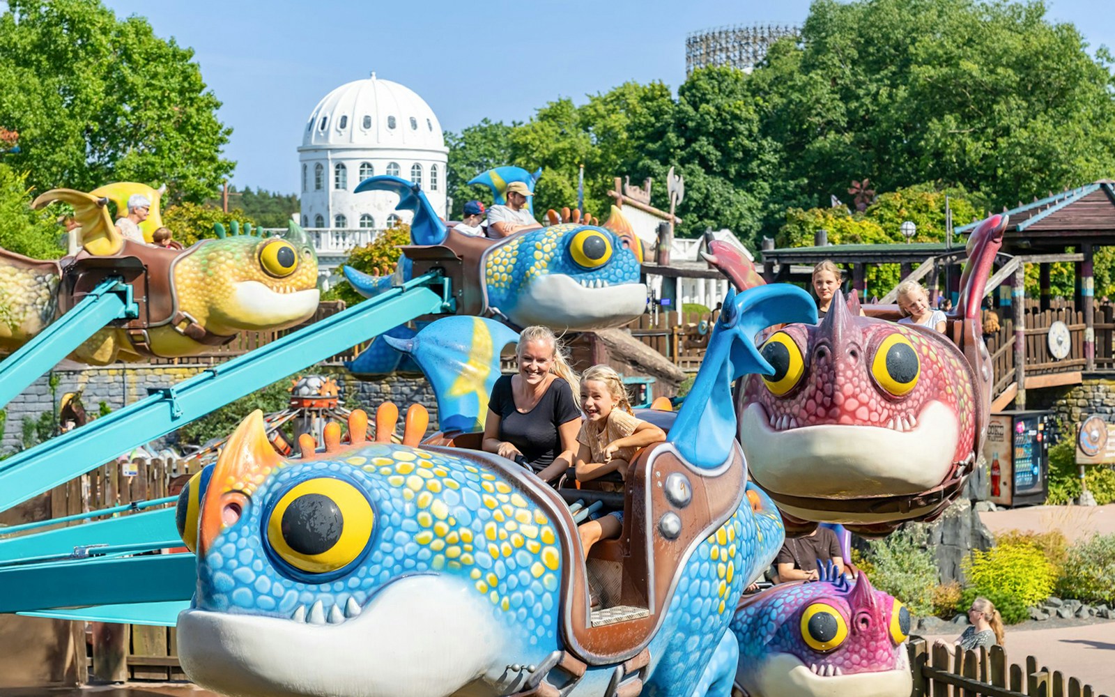 Young family enjoying a dragon-themed ride at Heide Park Resort, Hamburg.