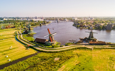 Traditional Dutch windmills along a river at Zaanse Schans, Netherlands.