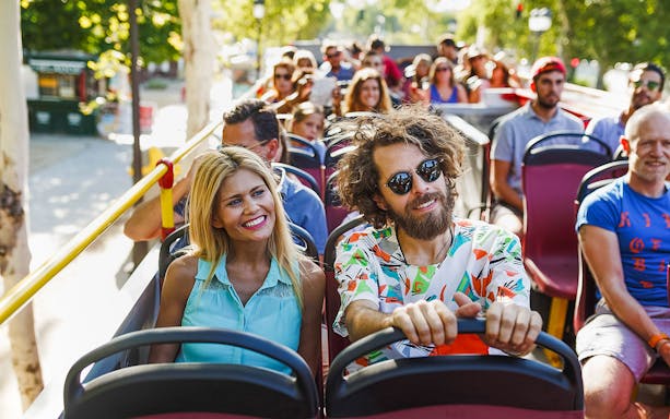 Passengers enjoying a City Sightseeing Bangkok tour on an open-top bus.
