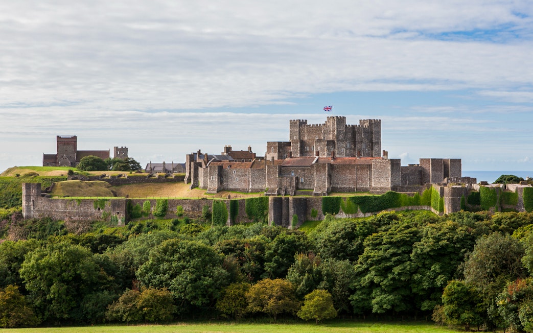 Dover Castle exterior with stone walls and lush greenery in Dover, England.