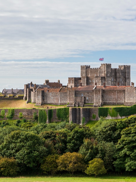 Dover Castle exterior with stone walls and lush greenery in Dover, England.
