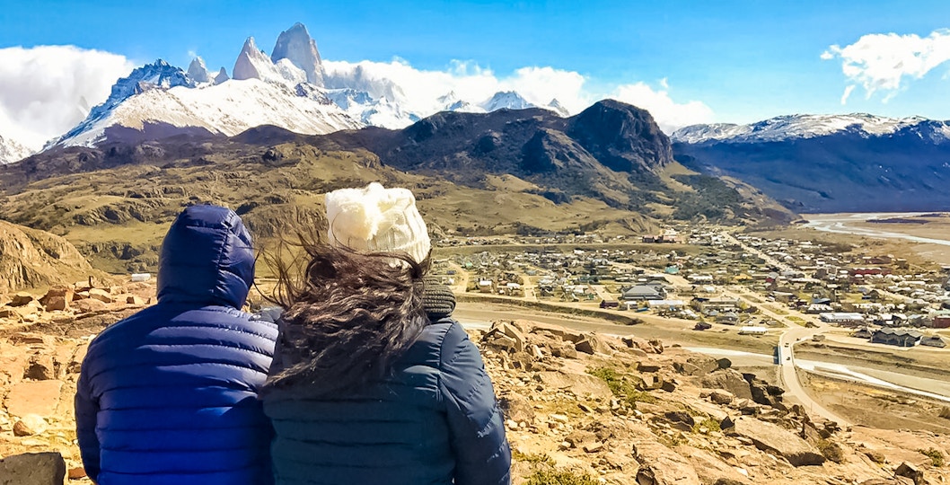 Tourists overlooking El Chaltén and Fitz Roy mountain range in Patagonia, Argentina.