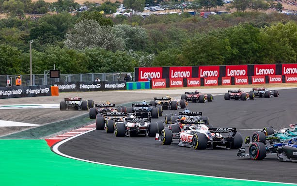 Formula 1 cars racing on a track at the Hungarian Grand Prix.