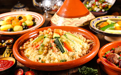 Assorted Moroccan tajine with couscous, vegetables, and chickpeas.