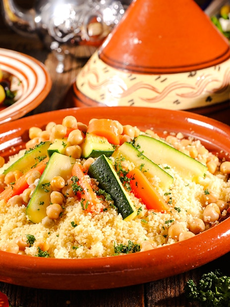 Assorted Moroccan tajine with couscous, vegetables, and chickpeas.
