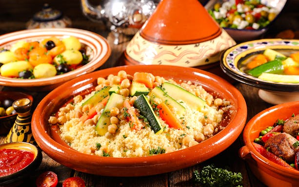 Assorted Moroccan tajine with couscous, vegetables, and chickpeas.