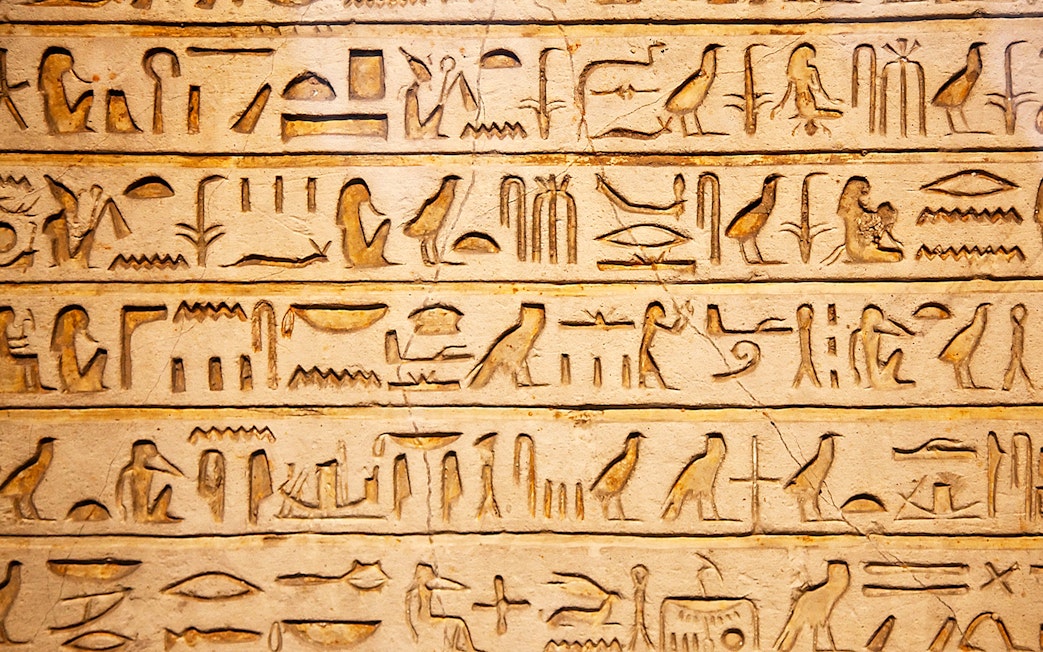 Hieroglyphs on a stone wall exhibit inside Kunsthistorisches Museum Vienna.