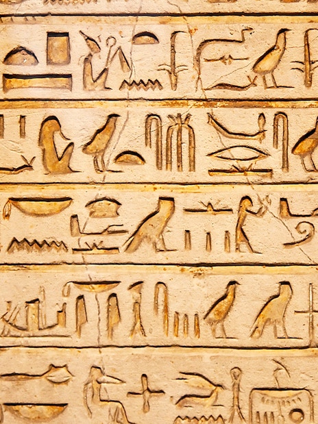 Hieroglyphs on a stone wall exhibit inside Kunsthistorisches Museum Vienna.
