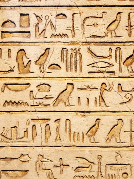 Hieroglyphs on a stone wall exhibit inside Kunsthistorisches Museum Vienna.