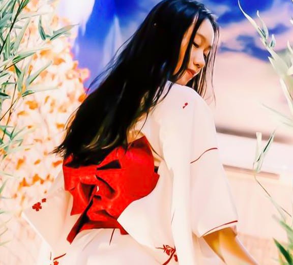 Person in traditional kimono at Joya Onsen surrounded by bamboo and floral decor.