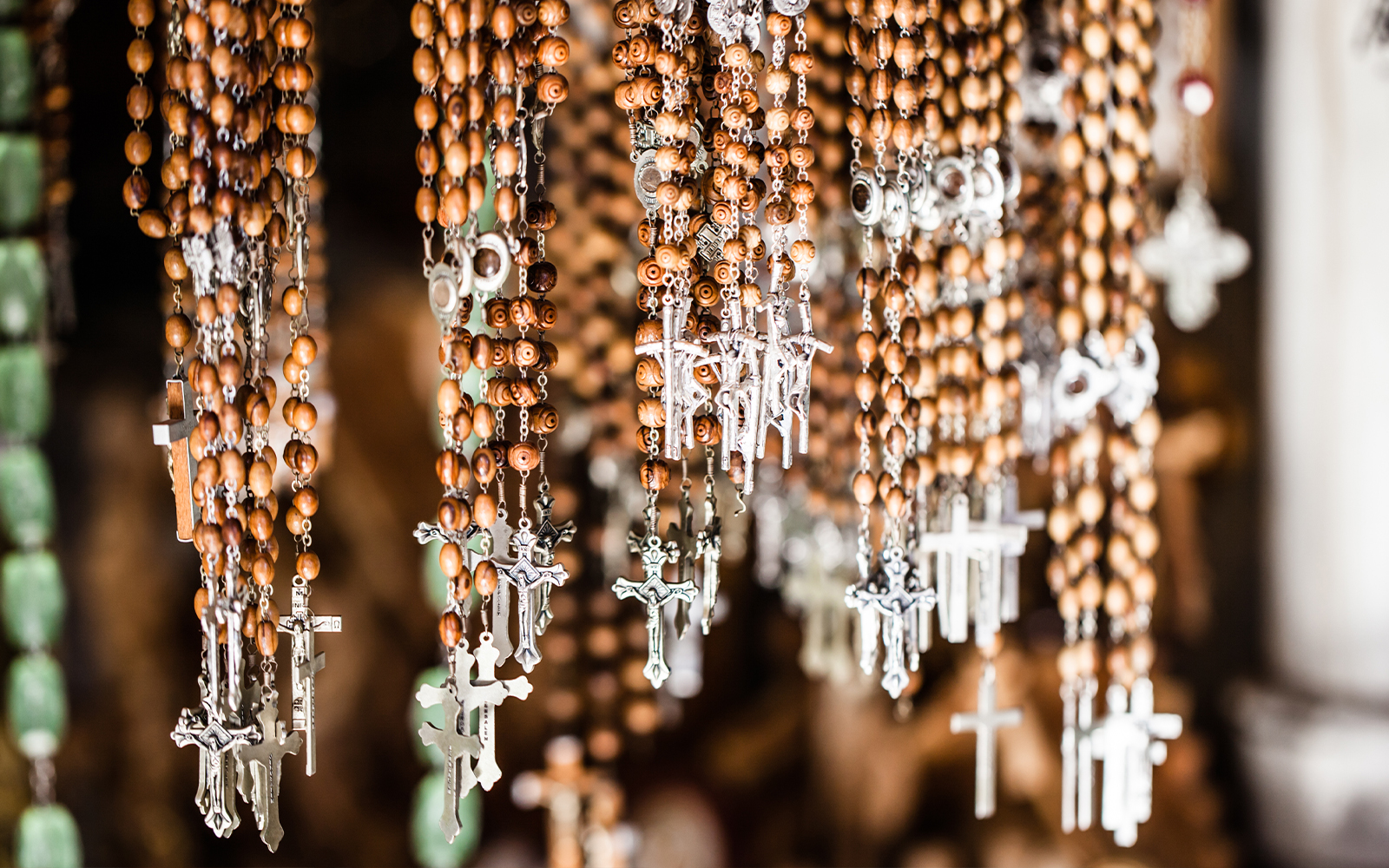 Rosary beads with Jesus Christ crosses in a church shop display.